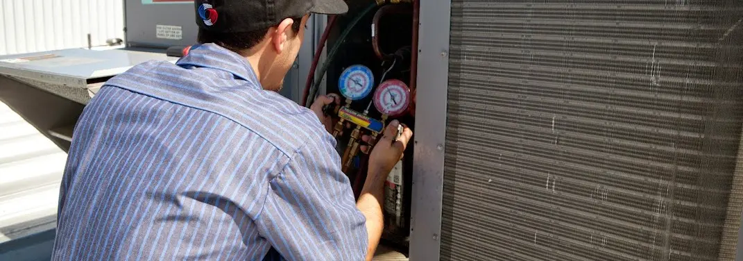 HVAC technician servicing a condenser unit in Hillsborough